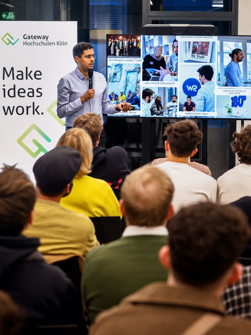 Mimoun Berrissoun spricht mit Mikrofon bei einer Veranstaltung; im Hintergrund eine Präsentationsfolie des Community Resilience Lab, im Vordergrund das zuhörende Publikum.